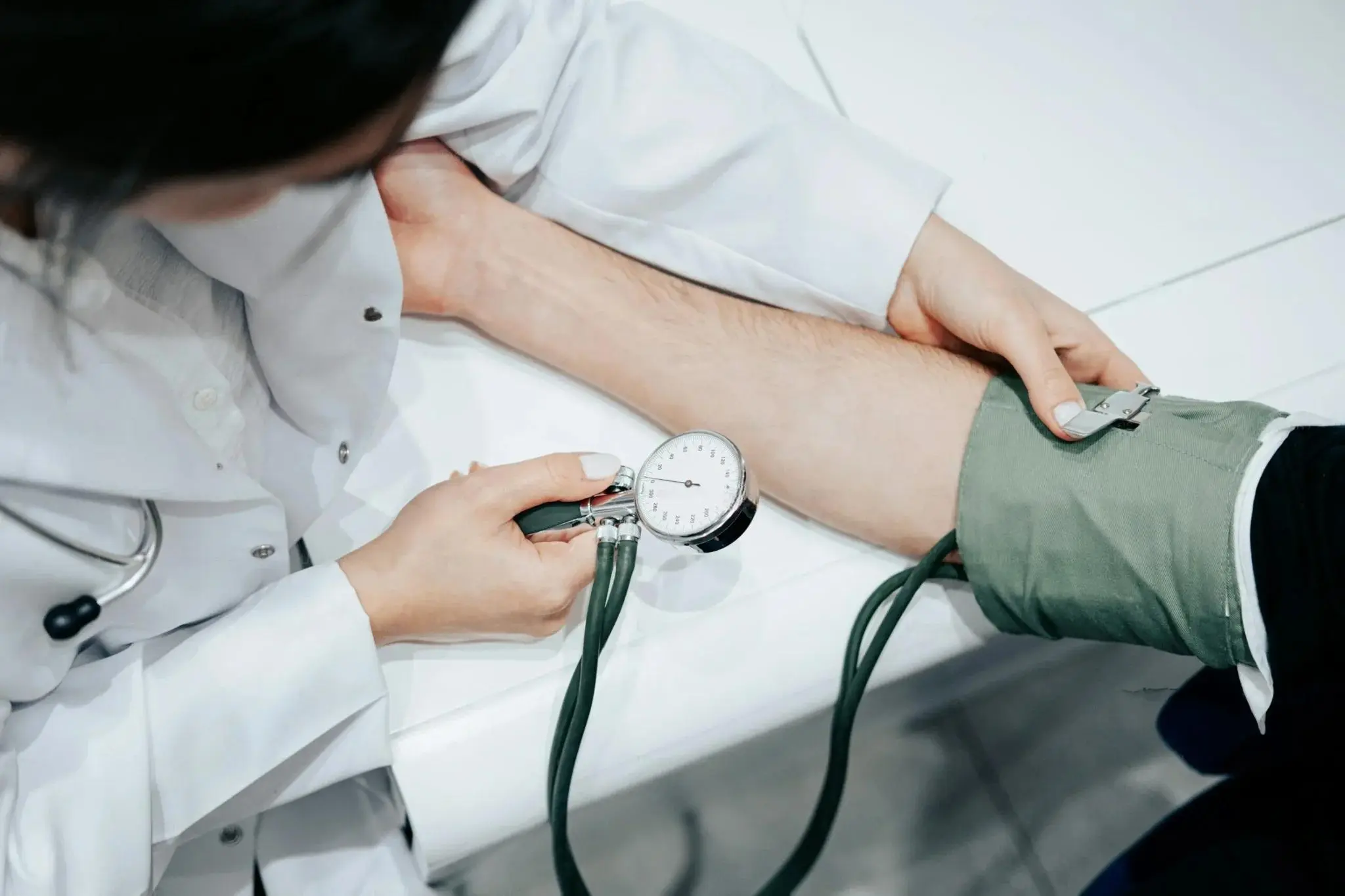 Healthcare professional measuring blood pressure in a medical setting at the best hospital for hypertension in Ahmedabad.